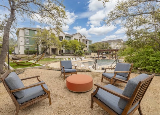 a patio with chairs and a pool and buildings
