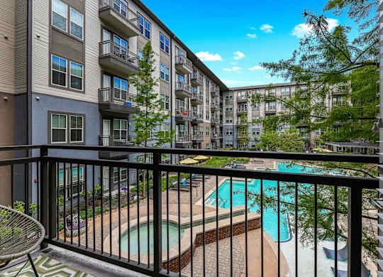 A balcony with a pool and a chair.