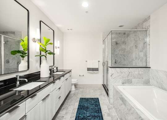 A bathroom with a marble floor and a white tub.