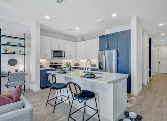 A kitchen with a white island and blue cabinets.
