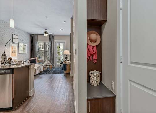 A kitchen with a washing machine and a hat on a hook.