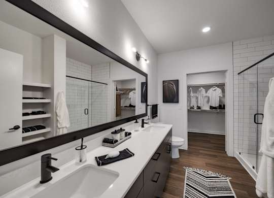 a bathroom with two sinks and a walk in shower in a 555 waverly unit