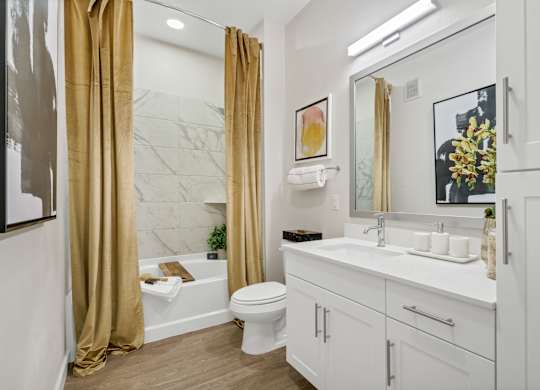 A bathroom with a white toilet, sink, and a marble wall.