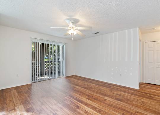 A room with wooden floors and a ceiling fan.