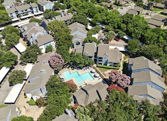 A bird's eye view of a residential area with houses and a swimming pool.