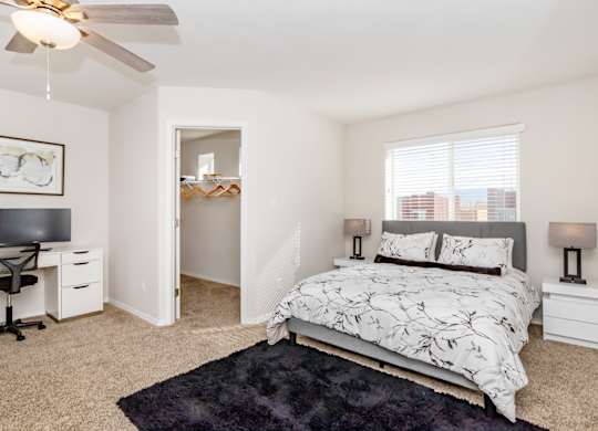 A bedroom with a bed, desk, and chair.