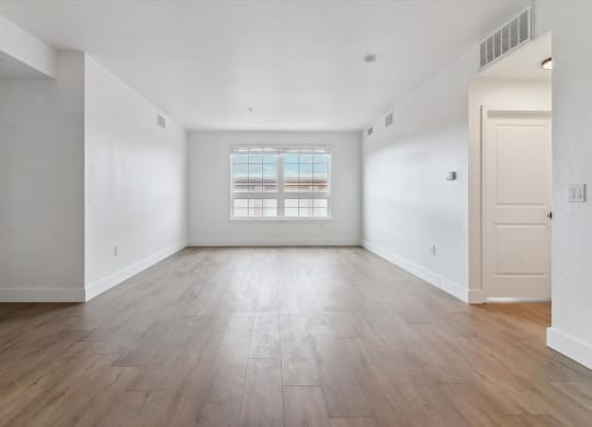an empty living room with white walls and wood floors