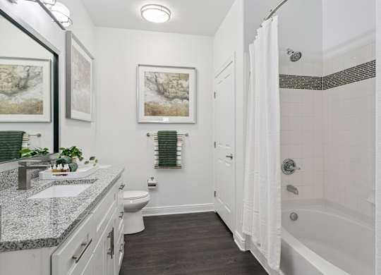 A bathroom with a white tub, sink, and toilet.