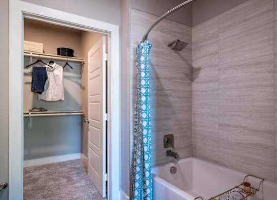 A bathroom with a white tub and a shower curtain.