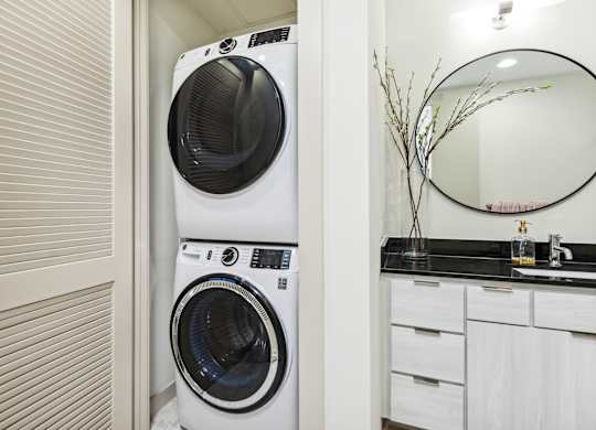 A white front loading washing machine in a laundry room.