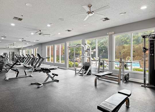 A gym with a variety of equipment including treadmills, weights, and exercise machines.