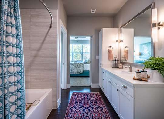 A bathroom with a white tub and a white sink.