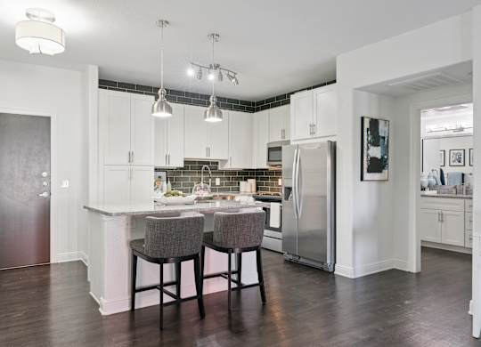 A kitchen with a table and chairs in the middle.