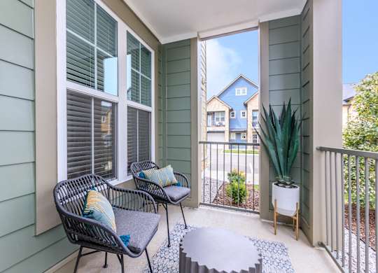 A balcony with a chair and a table.