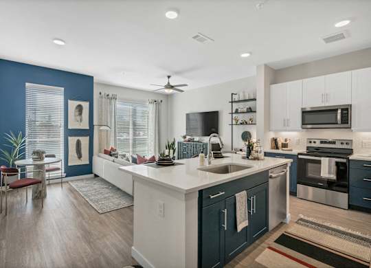 A modern kitchen with dark blue walls and white countertops.