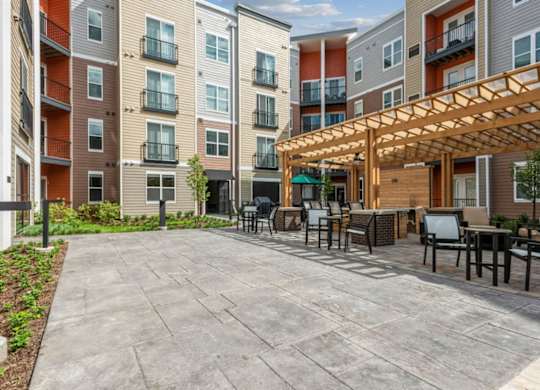 A patio area with a table and chairs is surrounded by apartment buildings.