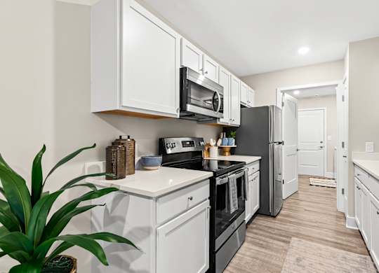 a kitchen with white cabinets and black appliances and a black refrigerator