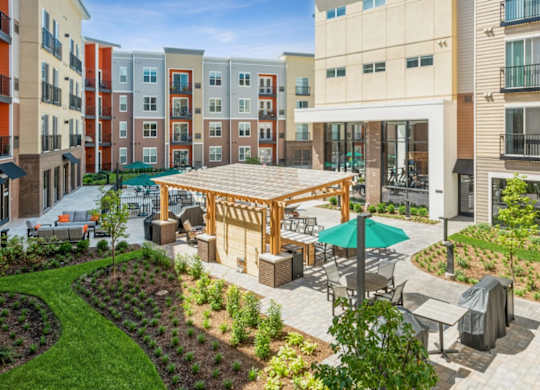 A patio area with a table and chairs is surrounded by apartment buildings.