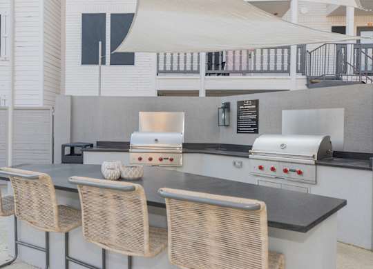 a kitchen with a bar with chairs and a grill