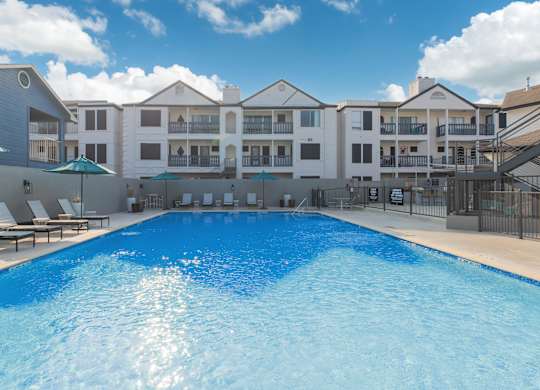 a large swimming pool with a building in the background