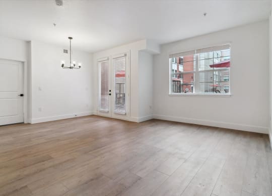 an empty living room with white walls and a window