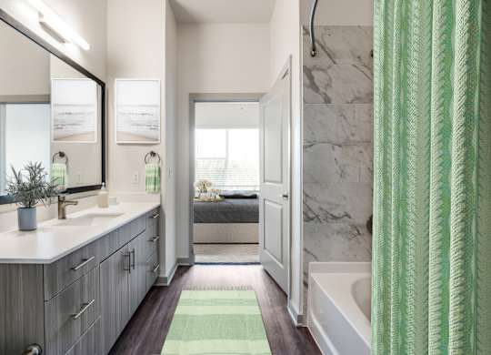 A bathroom with a green shower curtain and a white sink.
