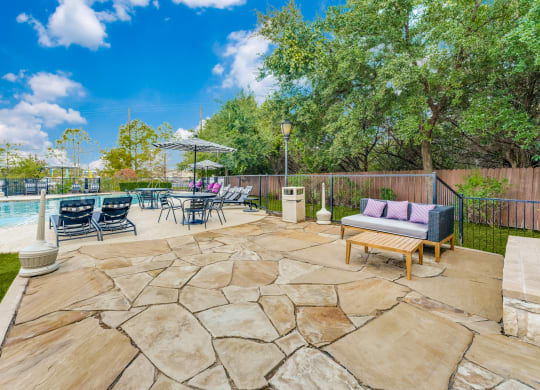 the backyard has a pool and patio with furniture and chairs