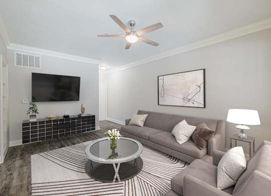 a living room with a couch and a table and a ceiling fan