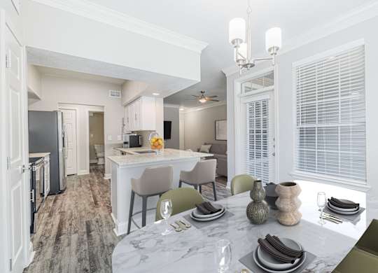 an open kitchen and dining room with a marble table and chairs