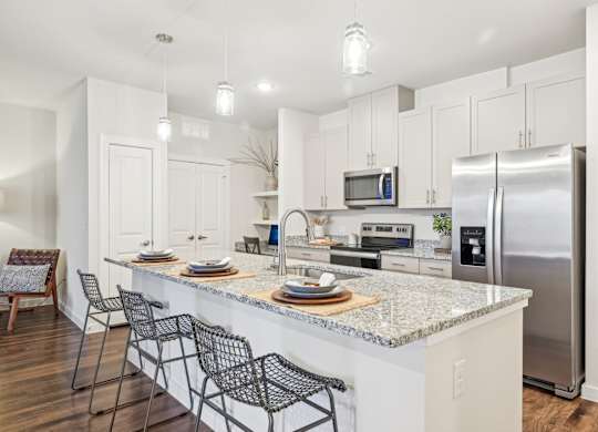 A kitchen with a white countertop and stainless steel appliances.