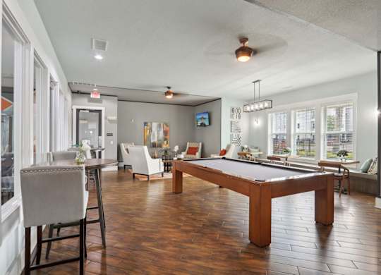 A room with a pool table and a television.