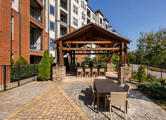 a patio with a table and chairs outside of an apartment building