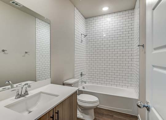A white bathroom with a sink, toilet, and bathtub.