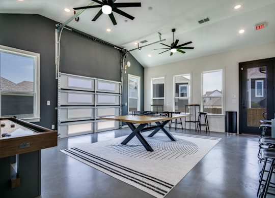 A room with a pool table and a ceiling fan.