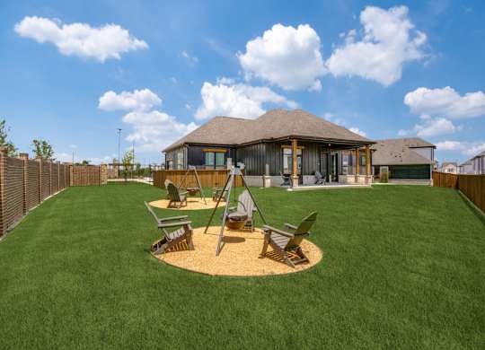 A house with a brown roof and a green lawn in front.
