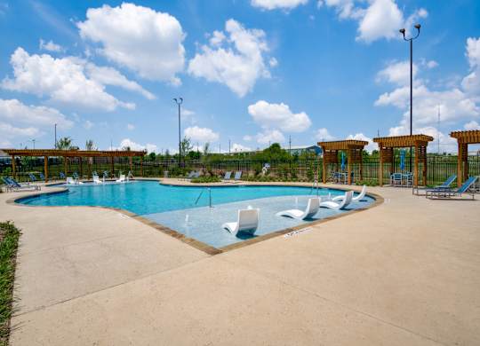 A large outdoor swimming pool with a sun lounger.