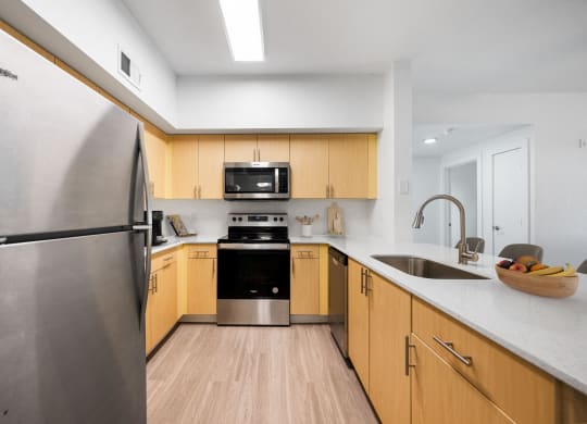 an empty kitchen with wooden cabinets and stainless steel appliances