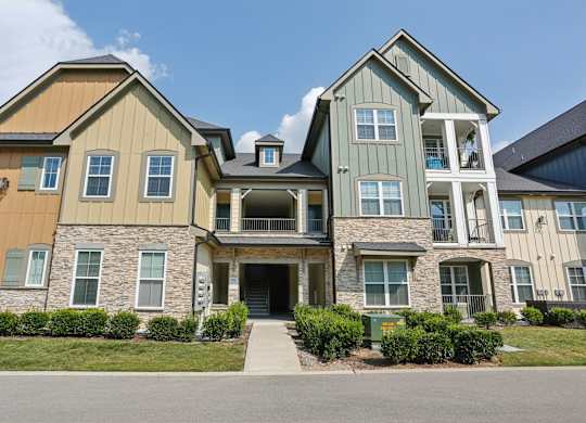 A large two-story house with a mix of stone and siding exterior.