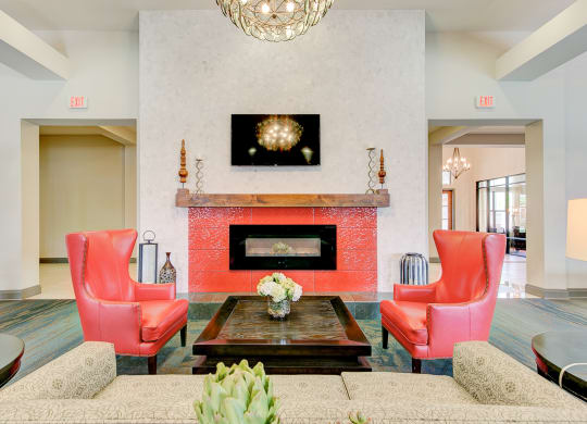 a living room with red chairs and a fireplace