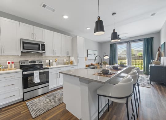 a kitchen with a large island and a table with chairs