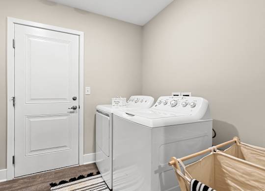 a utility room with a washer and dryer and a door to a bathroom