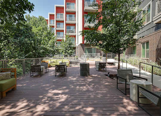 A wooden deck with chairs and a table in the middle of it.