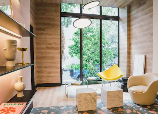 A yellow chair sits in a room with a large window.
