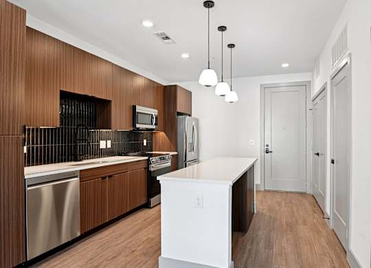 A modern kitchen with wooden cabinets and a white island.