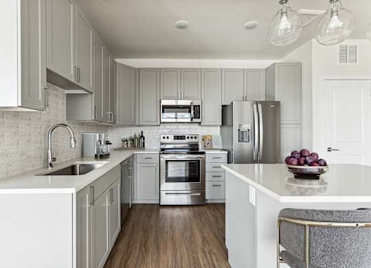 A modern kitchen with white cabinets and stainless steel appliances.