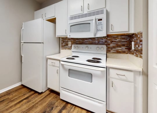 a kitchen with white appliances and a white refrigerator