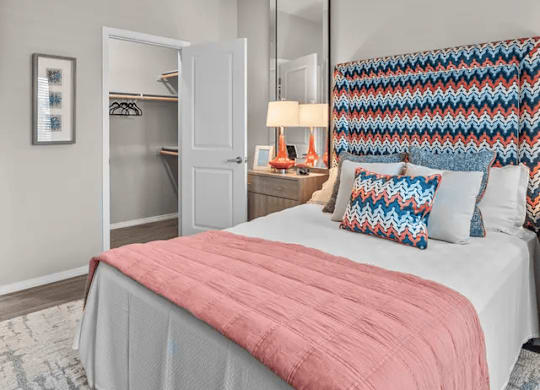 A bedroom with a bed, a ceiling fan, and a wardrobe.