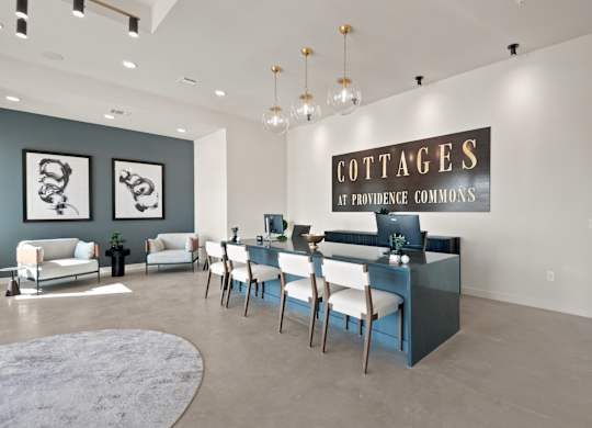 A room with a sign that says "Cottages at Providence Commons" on the wall.