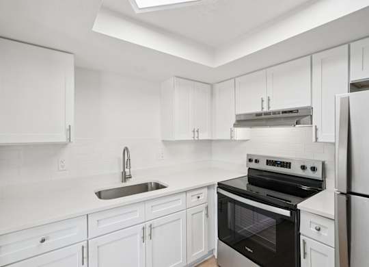 A white kitchen with a black oven and stove top.