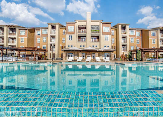 A large swimming pool in front of apartment buildings.